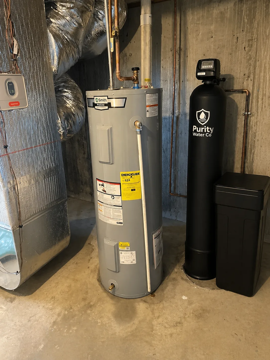 Installed Purity water softener system in a utility space beside home plumbing